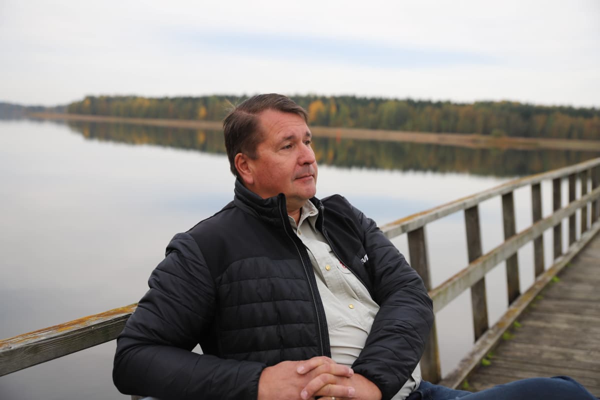 Lakeliving oy:n toimitusjohtaja John Lönnberg istuu laiturilla Sysmän uimarannalla