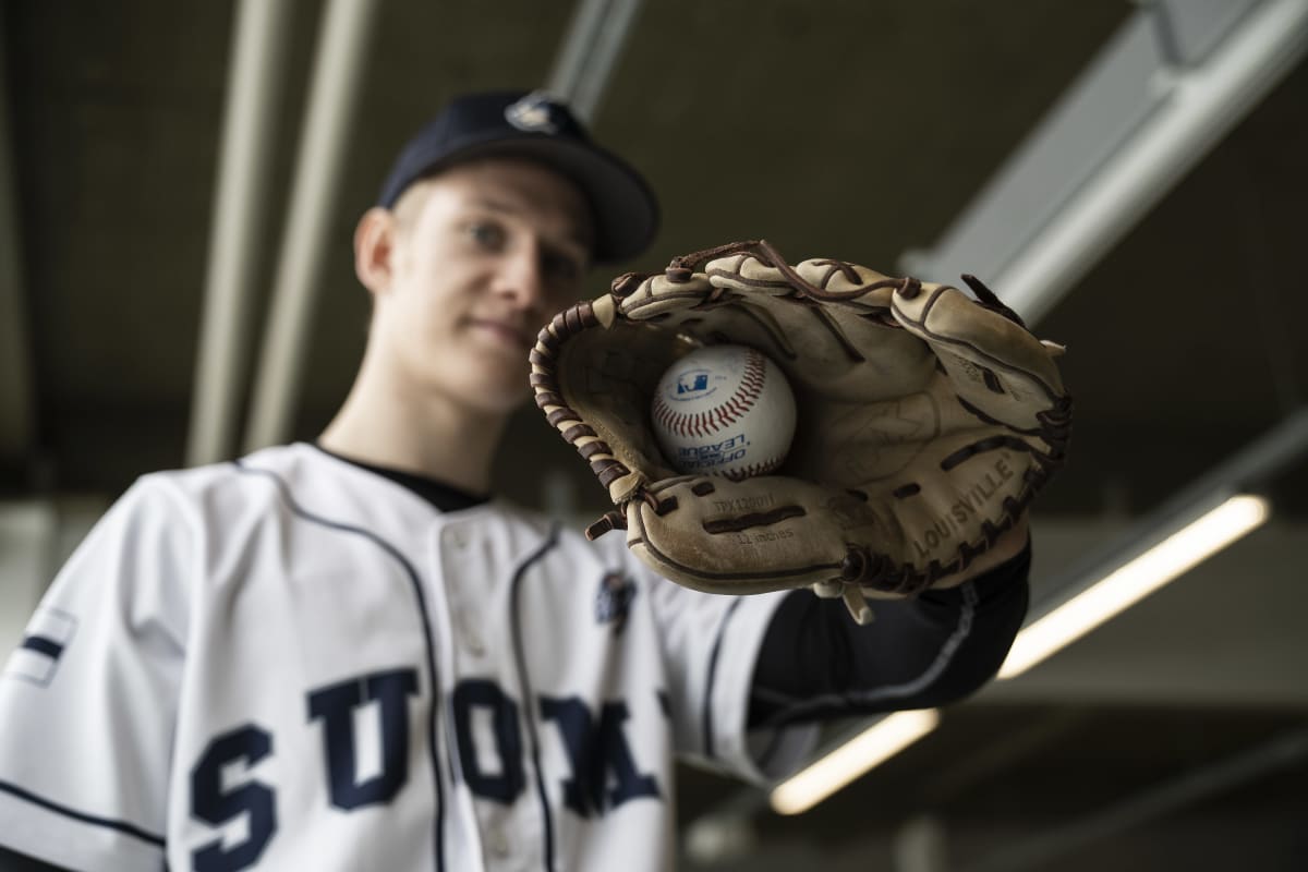Suomalainen basebaal pelaaja Konsta Kurikka näyttää baseball palloa räpylä kädessä.