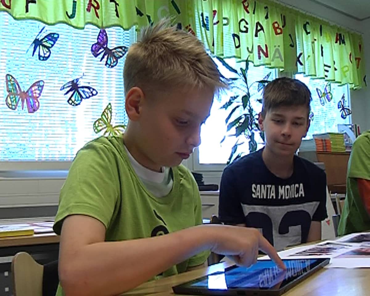 Pojat pelaavat kehittämäänsä muistipeliä tabletilla.