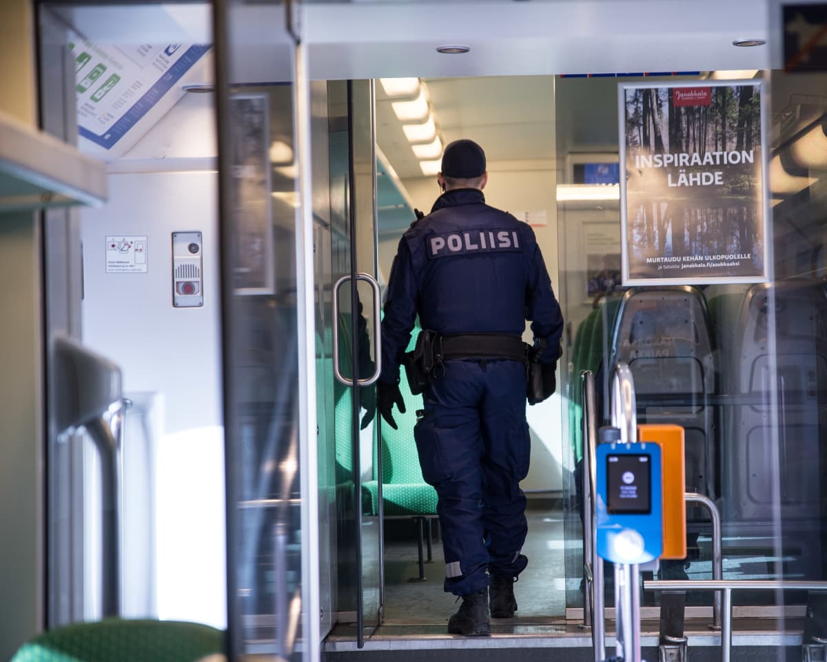 Poliisi tarkastamassa matkustusoikeudet junavaunussa.