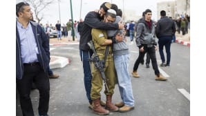 Ystävät halaavat toisiaan surressaan rabbi Itamar Ben Galin kuolemaa.