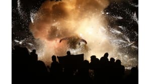 Ihmiset katselevat pyroteknistä härkää ilotulitteiden keskellä.