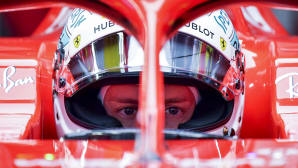Scuderia ferrarin tallin Sebastian Vettel keskittyy autossaan Shanghain Grand Prix'n harjoituksissa.