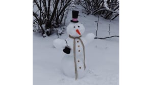Kukkarolla varustautunut lumiukko