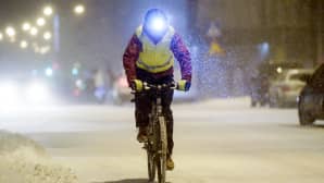 mies ajaa polkupyörällä tuiskussa