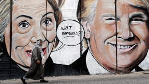 Graffiti Hillary Clintonista ja Donald Trumpista spreijattuna Länsirannan muuriin Israelissa.