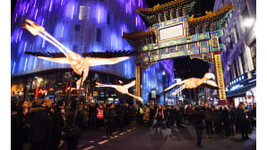 Ihmiset ihastelevat valotaidetta Lontoossa Chinatownissa.