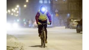 mies ajaa polkupyörällä tuiskussa