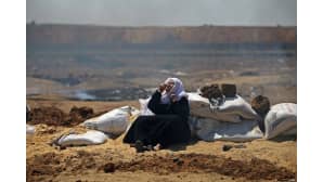 Palestiinalaisnainen suojaa hengitysteitään Israelin joukkojen kyynelkaasulta.