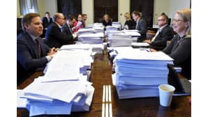 Perustuslakivaliokunta kokoontuneena suurien paperipinojen äärelle.