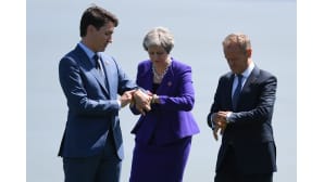 Kanadan pääministeri Justin Trudeau (vas.), Eurooppa-neuvoston puheenjohtaja Donald Tusk ja Britannian pääministeri Theresa May katsoivat kellojaan ryhmäkuvan ottamisen jälkeen G7-kokouksessa Charlevoixissa Kanadassa 8. kesäkuuta.