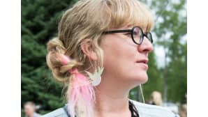 Lähikuva naisesta, jolla on vaaleanpunaista raitaa hiuksissaan.