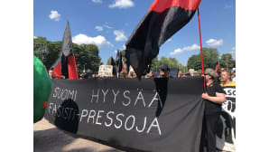 Anarkistimielenosoittajia lippuineen.