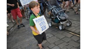 Nuorella pojalla kyltti kaulassa jossa lukee future voter 2031