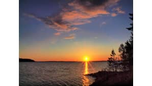 Auringonnousu järvimaisemassa.