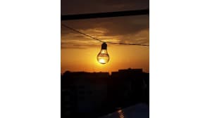 Aurinko paistaa hehkulampun takaa.