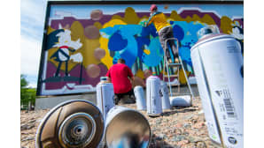Graffitin maalausta ja spray-pulloja.