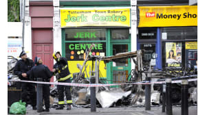 Poliiseja ja palomies palaneen bussin vieressä Tottenhamissa 7. elokuuta.