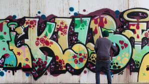 Graffitin maalaaja työssään.