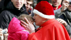 Paavi Benedictus XVI suutelee lasta Pyhän Pietarin aukiolla Vatikaanissa 28.12.2005.