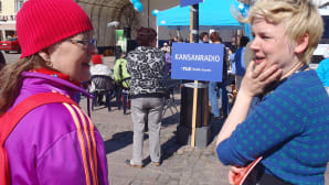 Kansanradion Reetta Arvila jututtaa yleisöä torilla.