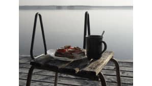 Voileipiä ja kahvikuppi jakkaralla laiturin nokassa.