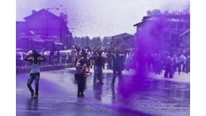 Kashmirin hallituksen työntekijät huutavat hallituksen vastaisia iskulauseita, kun poliisi suihkuttaa vesitykeillä violetin väristä vettä mielenosoittajien päälle Srinagarissa, Intiassa 8. heinäkuuta 2013.