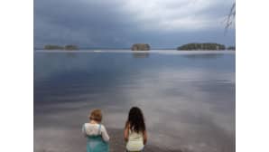 Kakis lasta rannalla katsomassa maisemaa