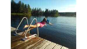 Tyttö hyppää laiturilta veteen