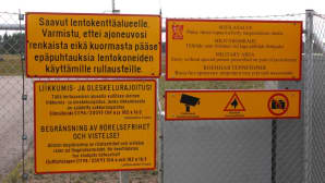 Kielto- ja varoituskylttejä Hallin lentokentän portilla.