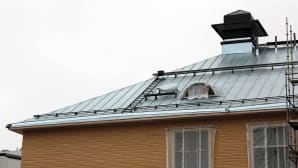 Puistokoulun uusi katto maalataan mustaksi vuonna 2016.