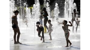 Lapset leikkivät Pariisilaisaukiolla, kun lämpötila kohosi 36 Celcius-asteeseen 31. maaliskuuta 2014.