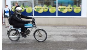 Poika ajaa mopolla Karstulan keskustassa.