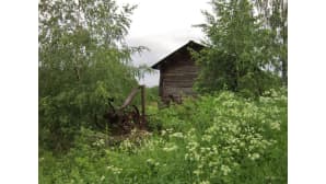 Vanhanaikainen lato ja ruostunut antiikkinen maatalouskone.