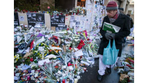 Mies kävelee pidelleen Charlie Hebdo -lehteä käsissään