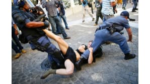 mielenosoittaja ja kaksi poliisia painivat kadulla