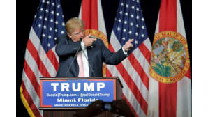 Donald Trump esittää tähtäävänsä aseella.