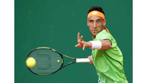 pelaaja iskee mailalla tennispalloa
