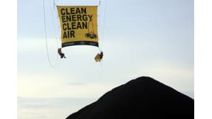 Indonesian Greenpeacen jäsenet ripustavat banneria. He yrittivät estää hiilen viemisen voimalaan Cirebonissa Indonesiassa.