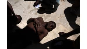 Libyan rannikkovartioston pelastama pakolainen makaa maassa epäonnistuneen merenylityksen jälkeen Tripolin rannikolla 8. heinäkuuta.