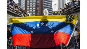 Mielenosoittaja pitelee Venezuelan lippua hallituksen vastaisessa tapahtumassa