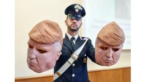 poliisi pitelee käsissään kahta naamaria