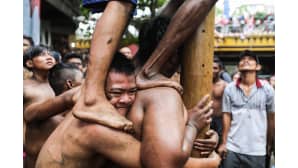 Miehet kiipesivät rasvattua tankoa pitkin Indonesian itsenäisyyspäivän juhlallisuuksissa Medanissa, Pohjois-Sumatralla 17. elokuuta.