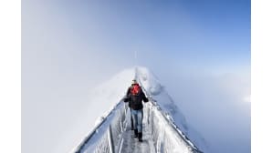 Kaksi turistia ylittävät riippusiltaa Col du Pillonissa Sveitsissä 20. joulukuuta.