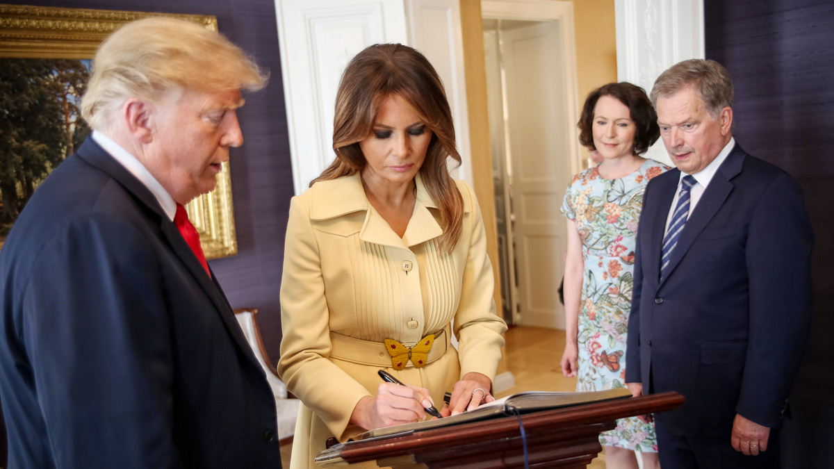 Melania Trump kirjoittaa nimensä presidentinlinnan vieraskirjaan.
