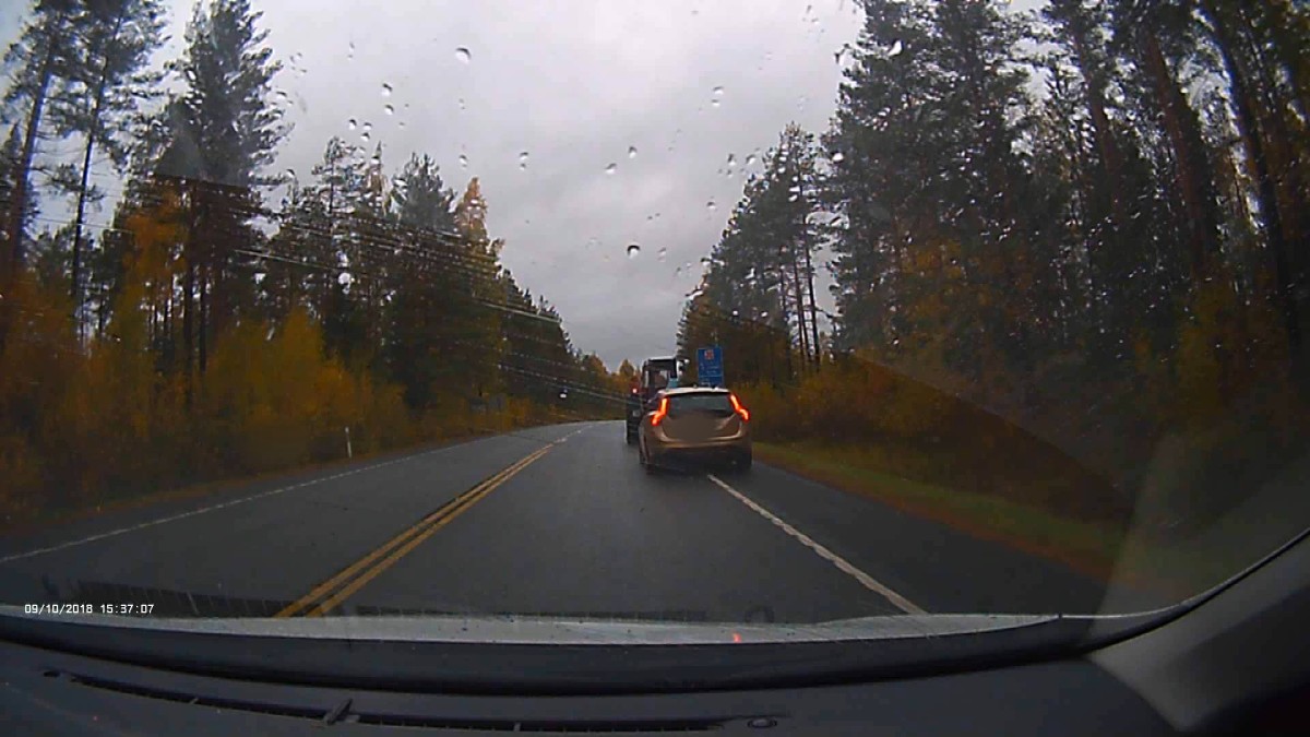 Henkilöauto ajaa hiljaista vauhtia traktorin takana Kasitiellä.