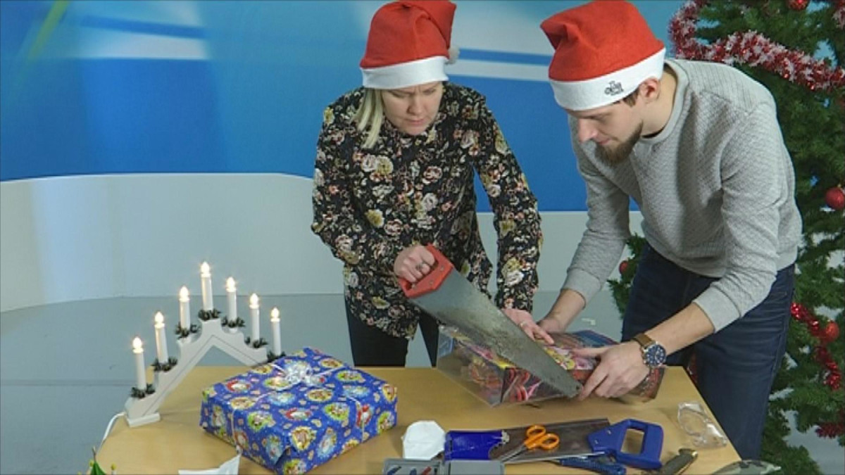 Kaksi toimittajaa avaavat lahjapakettia.