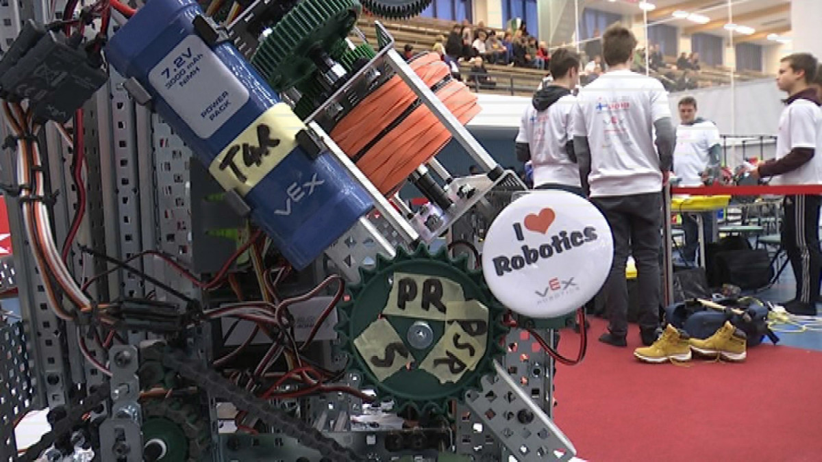 Robotiikan SM-kisoissa etualalla robotti, taustalla kilpailijoita ja yleisöä