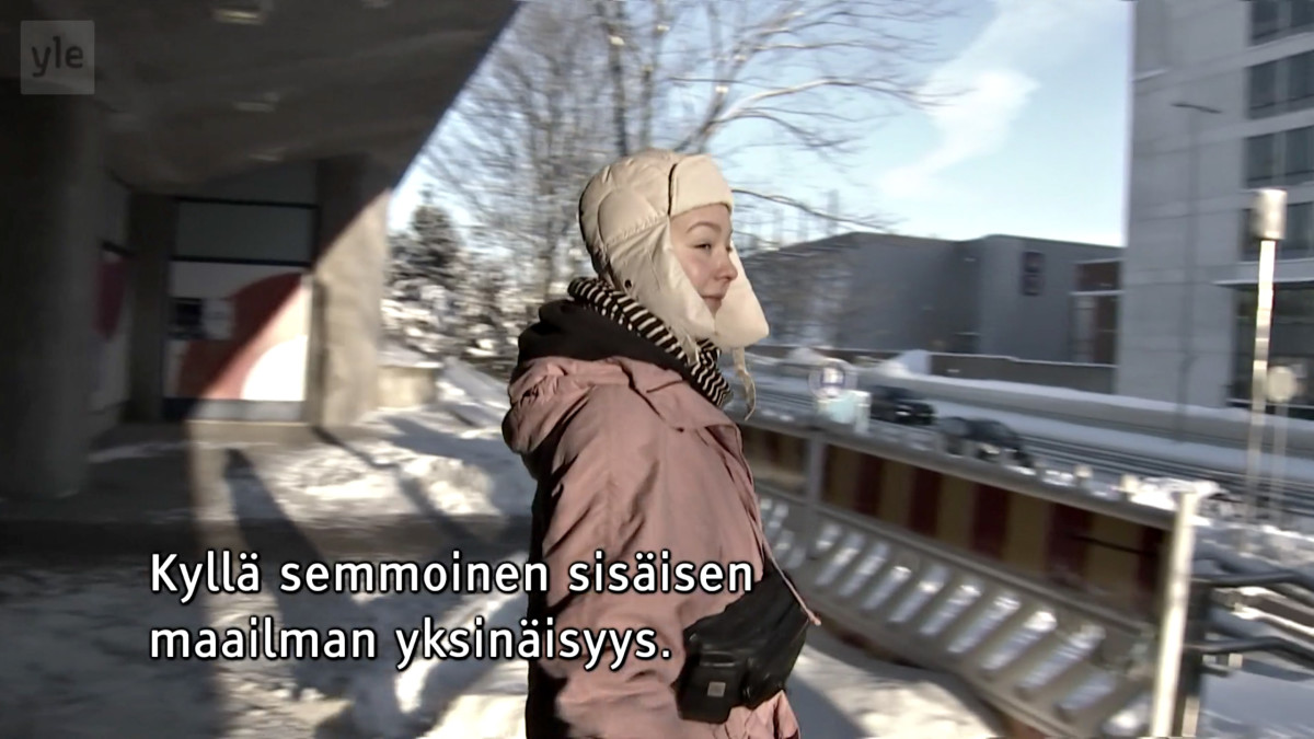 Nainen kävelee ulkona pakkasessa.