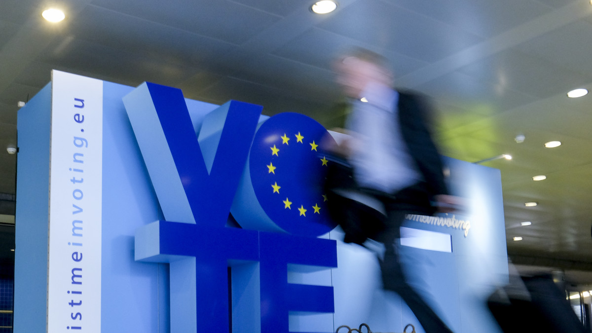 Mies kävelee ohi sinisen "vote"-kyltin.